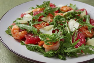 Fresh shrimp salad with arugula, grapefruit, and parmesan served in a bowl