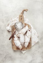 Bagels with filling, sweet pastries, sprinkled with powdered sugar, on a wooden board, dessert,
