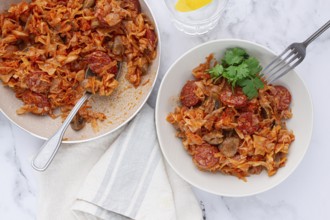 Bigos, Polish dish bigos, on the table, pan with stewed meat, with cabbage, chorizo sausages,