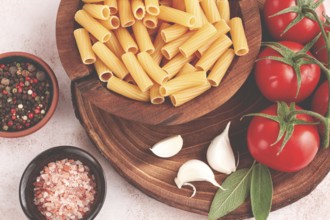 Pasta ingredients spread out, on a wooden surface, with tomatoes and spices, ready to cook, there