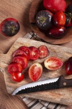 Sliced tomatoes, Black Beauty variety, on a cutting board, top view, on the kitchen table