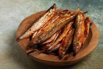 Cold smoked capelin, on a wooden bowl, top view, no people