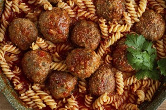 Minced meat meatballs, in tomato sauce, with fusilli pasta, in a cast-iron pan, homemade, no people
