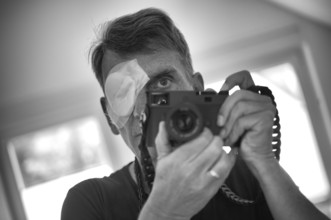 Portrait, self-portrait, selfie, photographer with eye bandage, eye injury, bandage on eye, holding