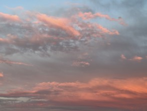 Reddish evening sky with altocumulus clouds above altocumulus clouds stratocumulus clouds below