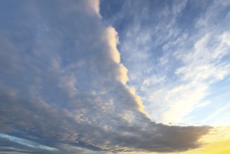 Cloud front with grey stratocumulus below right left and bright altocumulus clouds above