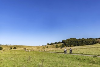Pristine landscape in the Swabian Alb biosphere reserve with blue skies and cyclists. The former