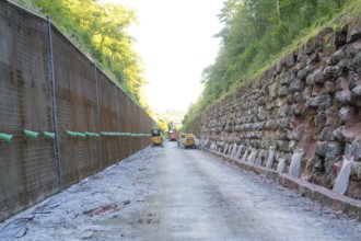 Machines on a construction site between steep walls overhung by trees, Hermann Hessebahn