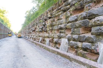 Long rock wall along a dusty construction site path, Hermann Hessebahn construction site, Calw,