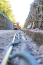 Cable and rock wall on a construction site with construction machinery, Hermann Hessebahn