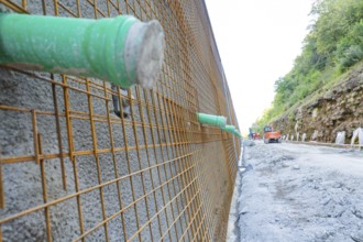 Close-up of a construction wall with metal mesh and green pipes, Hermann Hessebahn construction