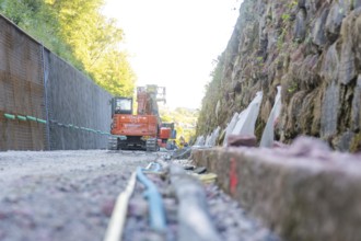 Excavator on a rock wall at an outdoor construction site, Hermann Hessebahn construction site,
