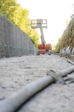 On a construction site, a working platform lifts between concrete walls in the forest, Hermann