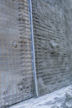 Close-up of a concrete wall with visible wire mesh on a construction site, Hermann Hessebahn