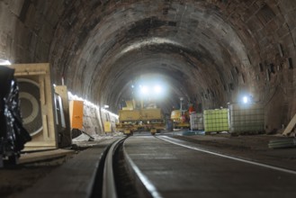 Construction work in the tunnel with machines and lighting along the tracks, construction of the