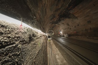 Tunnel with tracks and construction work, illuminated by line lights, construction of the Hermann