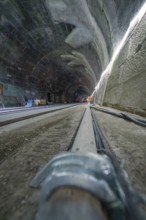 Rough tunnel construction with railway tracks from a low perspective, construction of the Hermann