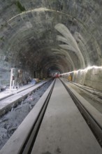 An unfinished tunnel with rails, in a dark, rough construction site environment, construction of