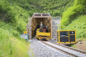 Construction vehicle near a tunnel in a green, natural environment, construction of the Hermann