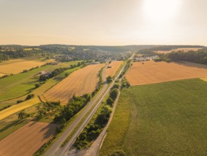 Natural landscape with fields and village, taken from above, illuminated by the sunset,