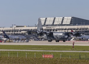 Stuttgart Airport with terminal and US Air Force Lockheed L-100 Hercules aircraft landing.