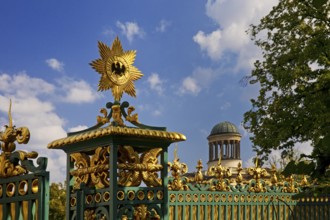 Golden star with black eagle on the fence of Charlottenburg Palace and dome of the Stüler Building,