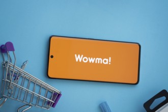 Dhaka, Bangladesh- 03 July 2025: Smartphone displaying wowma logo with shopping cart on a blue