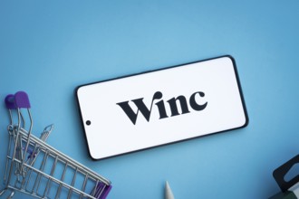 Dhaka, Bangladesh- 03 July 2025: Smartphone displaying Winc logo with shopping cart on a blue