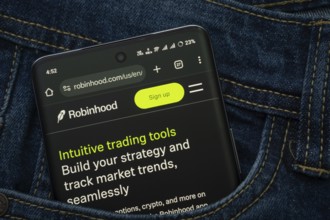 Dhaka, Bangladesh- 15 June 2025: A smartphone displaying the Robinhood web interface peeks out of a