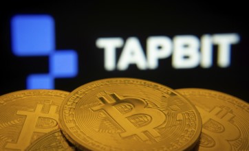 Dhaka, Bangladesh- 20 Sep 2025: Close-up of Bitcoin coins with thex Tapbit logo visible on a screen
