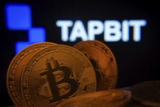 Dhaka, Bangladesh- 20 Sep 2025: Close-up of Bitcoin coins with thex Tapbit logo visible on a screen