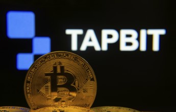 Dhaka, Bangladesh- 20 Sep 2025: Close-up of Bitcoin coins with thex Tapbit logo visible on a screen