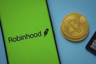 Dhaka, Bangladesh- 26 Aug 2025: Robinhood logo on smartphone screen near Bitcoin coin and QR code