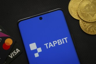 Dhaka, Bangladesh- 20 Sep 2025: Smartphone displaying Tapbit logo surrounded by Bitcoin coins and