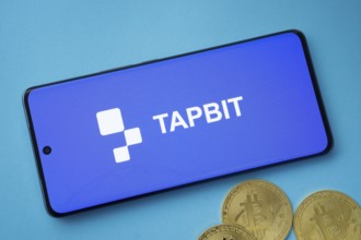 Dhaka, Bangladesh- 19 Sep 2025: Tapbit logo on smartphone screen near Bitcoin coin and QR code on