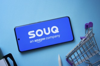 Dhaka, Bangladesh- 03 July 2025: Smartphone displaying Souq logo with shopping cart on a blue