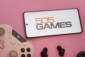 Dhaka, Bangladesh- 23 Sep 2025: Smartphone with 505 Games logo, game controller, and earbuds on a