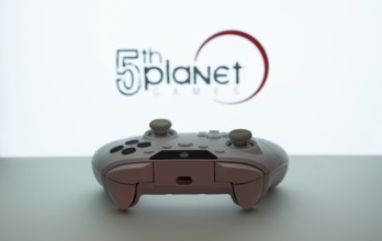 Dhaka, Bangladesh- 23 Sep 2025: Game controller in front of 5th planet games logo on a blue
