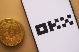 A Bitcoin and OKX logo on a white screen with black text