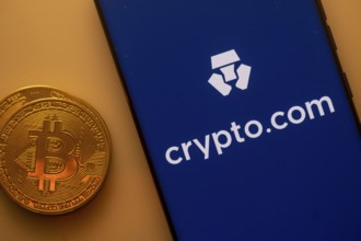 A Bitcoin and Crypto.com logo on a blue screen representing cryptocurrency