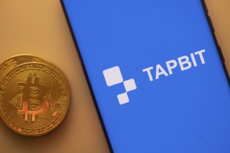 A Bitcoin and Tapbit logo on a blue screen representing cryptocurrency