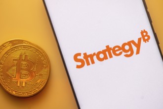 A Bitcoin and Strategy logo on a white screen with orange text