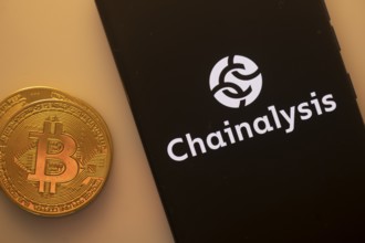 A Bitcoin coin next to a Chainalysis logo on a black background