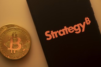 A Bitcoin coin next to a Strategy logo on a black background