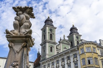 Baroque sculpture next to a building with towers and cloudy sky, Old Cathedral Ignatius Church Old