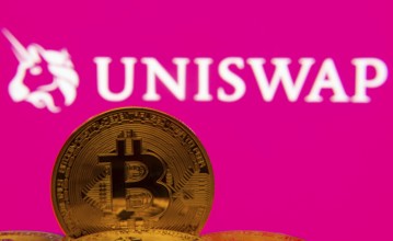 Dhaka, Bangladesh- 09 Sep 2025: Close-up of Bitcoin coins with the Uniswap logo visible on a screen