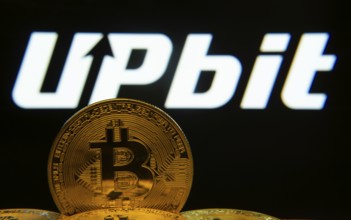 Dhaka, Bangladesh- 18 Sep 2025: Close-up of Bitcoin coins with thex Upbit logo visible on a screen