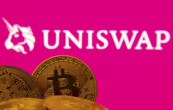 Dhaka, Bangladesh- 09 Sep 2025: Close-up of Bitcoin coins with the Uniswap logo visible on a screen