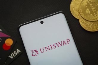 Dhaka, Bangladesh- 19 Sep 2025: Smartphone displaying Uniswap logo surrounded by Bitcoin coins and