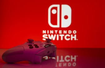 Dhaka, Bangladesh- 15 July 2025: Smartphone with nintendo switch logo, game controller, and earbuds